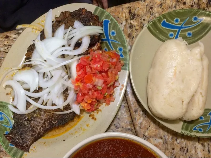 A Ghana food dish of banku and fish with vegetables